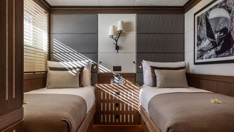 A guest stateroom in Alice's interior, finished in the same natural, textural material palette as the saloon.