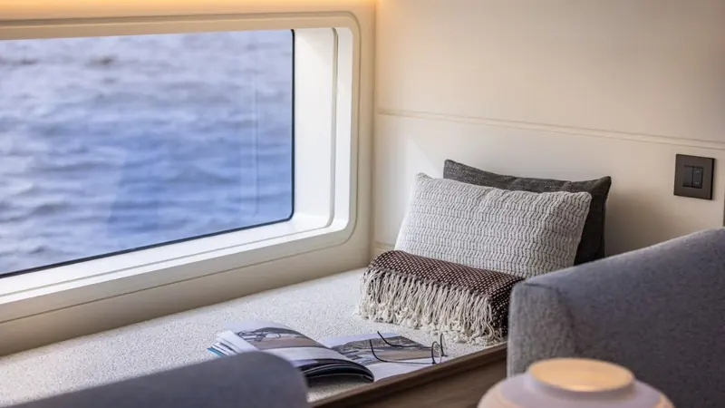 A window seat below decks, one of several spots the deckhouse's extensive glazing was designed to illuminate.