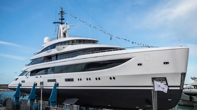 A three-quarter bow view at the quay shows the fold-out Oasis Deck side wings and the continuous glazing RWD drew for both hulls in the pair.