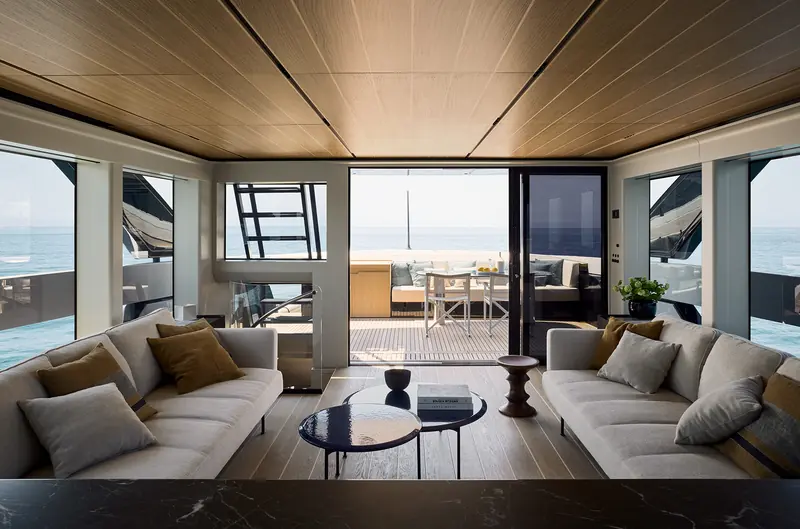 The main-deck salon opens directly onto the aft cockpit and dining area, keeping sightlines to the water from the main living space.