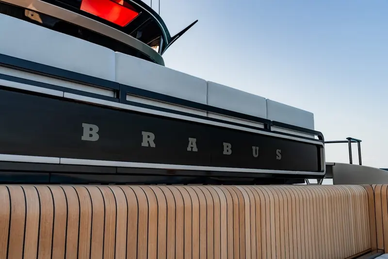 The BRABUS lettering along the hull, alongside the teak-lined side deck.