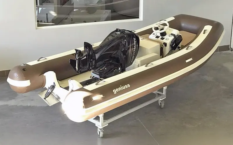 Mid-retraction: the outboard tilted forward on its bracket, ahead of the folding transom closing behind it. This is the mechanism, not a static mount.
