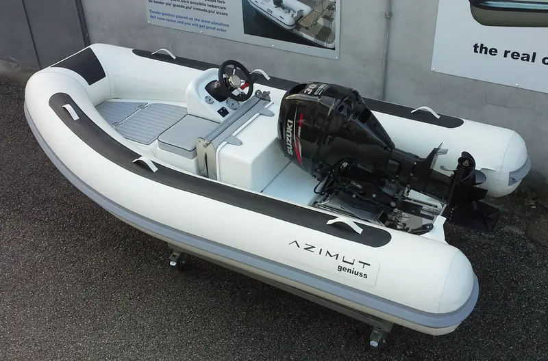 A dealer-branded Geniuss RIB fitted with a Suzuki outboard, photographed in the workshop before delivery.