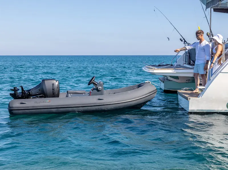 A Geniuss tender alongside a catamaran at sea, the setting most large tenders actually work in.