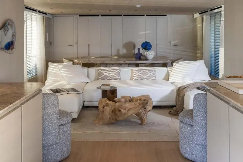 The main salon, its driftwood coffee table and stone-topped dining table part of Francesco Paszkowski's natural-material interior.
