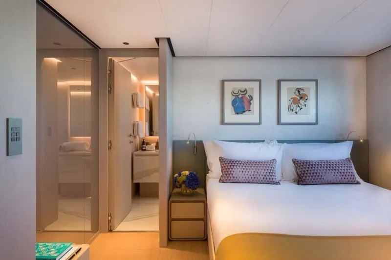 One of five guest staterooms, each with its own en suite behind a frosted-glass door.