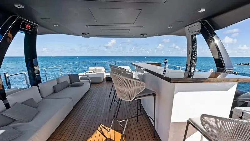 The same foredeck seating from the flybridge, with the yacht's owner-facing helm visible through the windscreen above it.