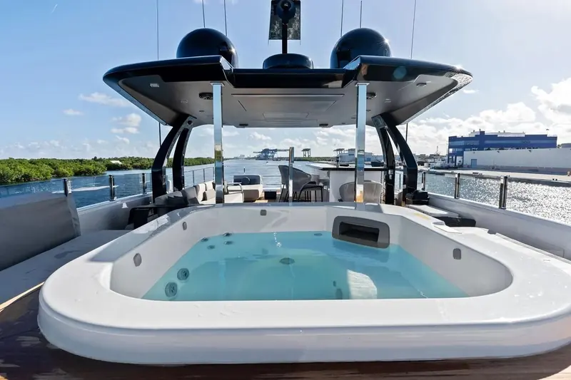 The flybridge Jacuzzi, positioned forward of the bar with the surrounding marina visible astern.