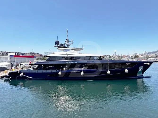 Queen Yaz against an Istanbul waterfront skyline. The sundeck, the uppermost open deck here, is designed as the yacht's main social space.