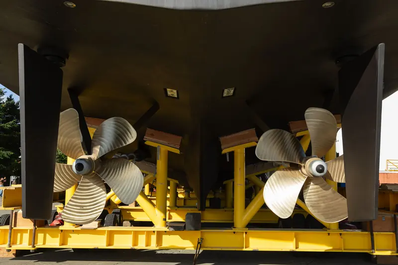 A close look at Zembra's twin five-blade propellers and rudders while she is still cradled in the lift.