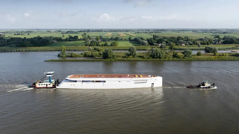 Under tow past Dutch farmland on the way to Feadship's Amsterdam facility, where the superstructure will be joined and outfitting will begin.