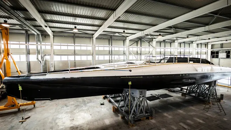 Ferrari's Hypersail hull just after demoulding in Pisa in May 2026 - the needle-fine bow and low freeboard built for a 30-metre foiling monohull, not for cruising comfort.