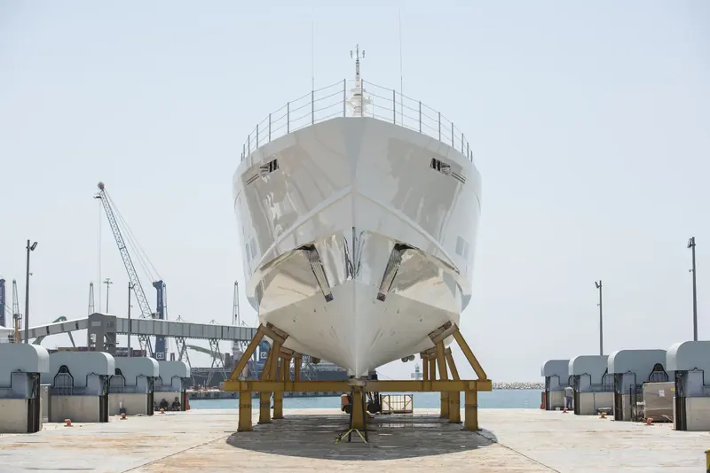 Genie Blu bow-on at her launch at Antalya. The near-plumb stem and the hard chine running aft are what a semi-displacement aluminium hull looks like before the paint crew finish with it; she is 45 metres long on an 8.89 metre beam.