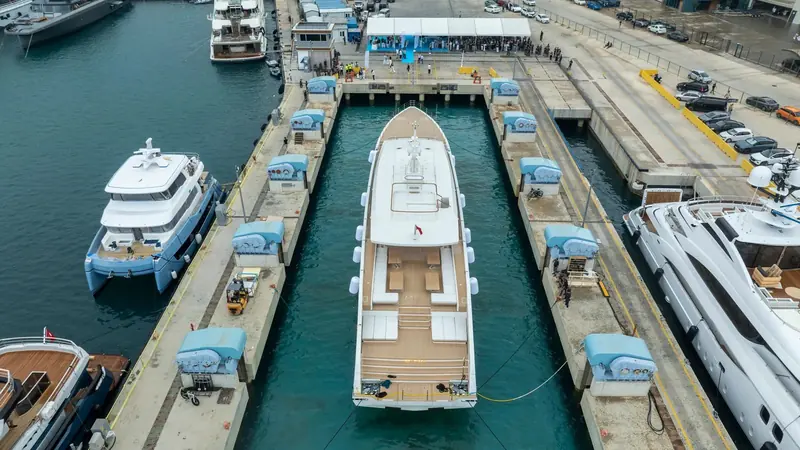 In the launch basin at the yard, with the naming marquee on the quay. Alia has delivered Al Waab, Samurai, Ruya and Phi Phantom from this site; Genie Blu left it on 1 August 2026 bound for Italy.