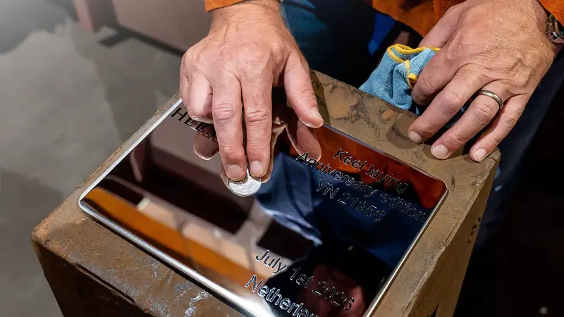 The plaque set into the keel: 'Keel laying, Anniversary edition, YN 21956, July 1st 2026, Netherlands', with the 1978 coin marking Heesen's founding year.
