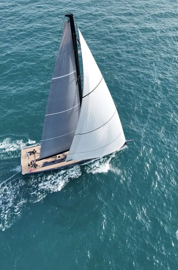 From above, Mavi's twin-cockpit deck separates the working sail-handling area forward of the wheels from the guest zone aft.