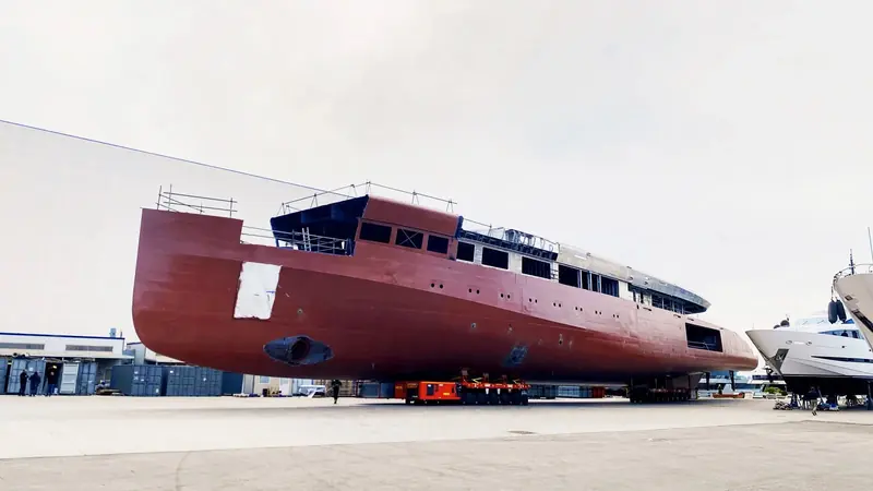 Belita's hull in red construction primer, moved on a self-propelled modular transporter earlier in the build - the stage most launch-day photography skips past.