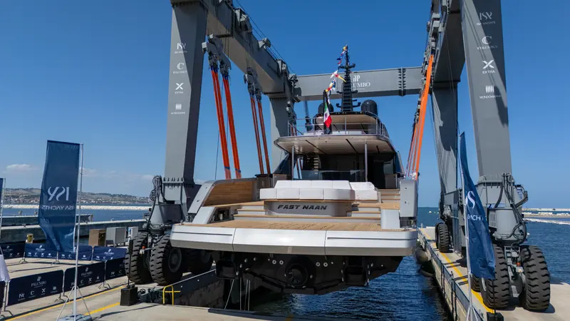 Her name on the transom as the lift lowers her, with Palumbo Superyachts' four brands - ISA, Columbus, Extra and Mondomarine - on the gantry above.