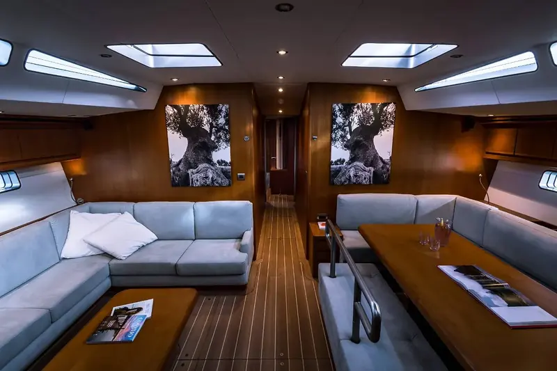The saloon after Vitters Shipyard's 2018 rebuild of the yacht under the project name Take Fife, finished in varnished wood with framed artwork either side of the companionway.