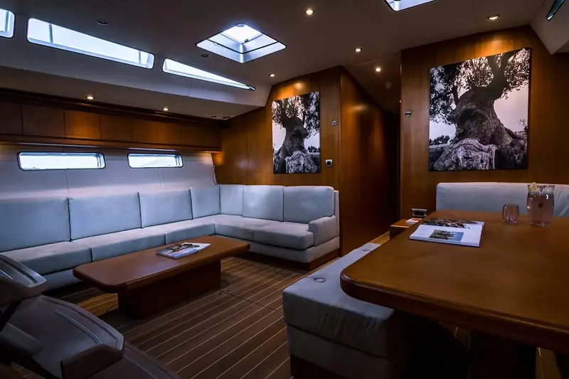 A second view of the rebuilt saloon, looking aft toward the chart table and the U-shaped seating around the dining table.