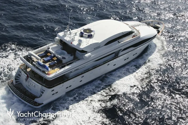 Laurie I underway. The transom lettering still reads Wheels, Valletta, one of the yacht's earlier names and her Malta home port, the flag now at the centre of the anchoring case.