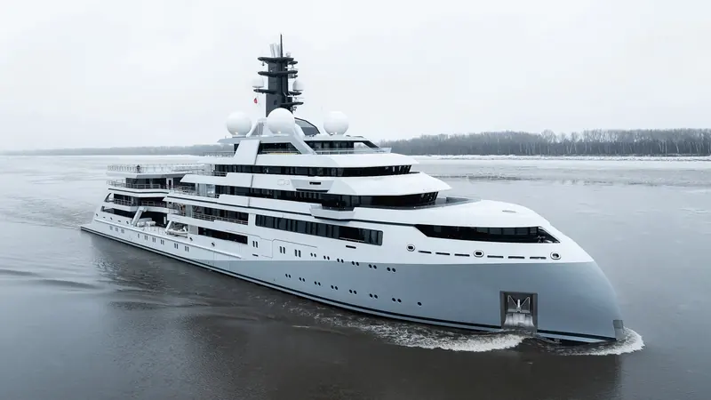 O3 under way on the Weser during sea trials in early 2026, ice still visible along the banks. The axe-style bow and grey-hulled profile are Espen Oino's 2022 redesign, not the yacht's original 2018 specification.