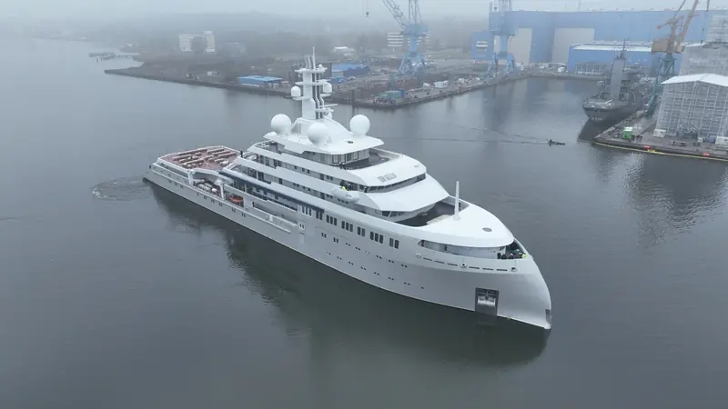 O3 leaving Lurssen's Peene-Werft basin at Wolgast, a German naval support vessel moored behind her. She spent the earlier part of her build here before moving to Hamburg for the redesigned superstructure.