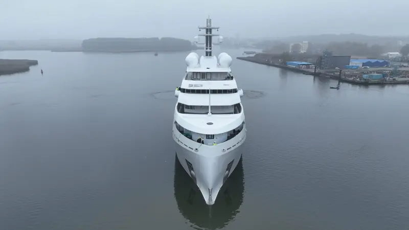 Head on, showing the ice-classed hull's raked stem and the crew still aboard for delivery trials. The forward-sited superstructure is a functional choice on an expedition hull, not a styling one.