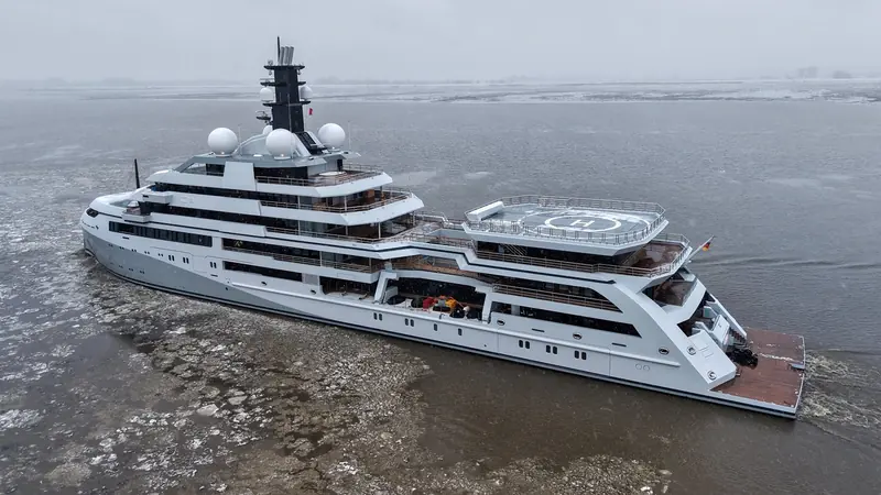 The aft helideck added in the 2022 redesign, seen from above with crew on deck. BOAT International and YachtBuyer both describe it as one of the most visible changes the new owner ordered.