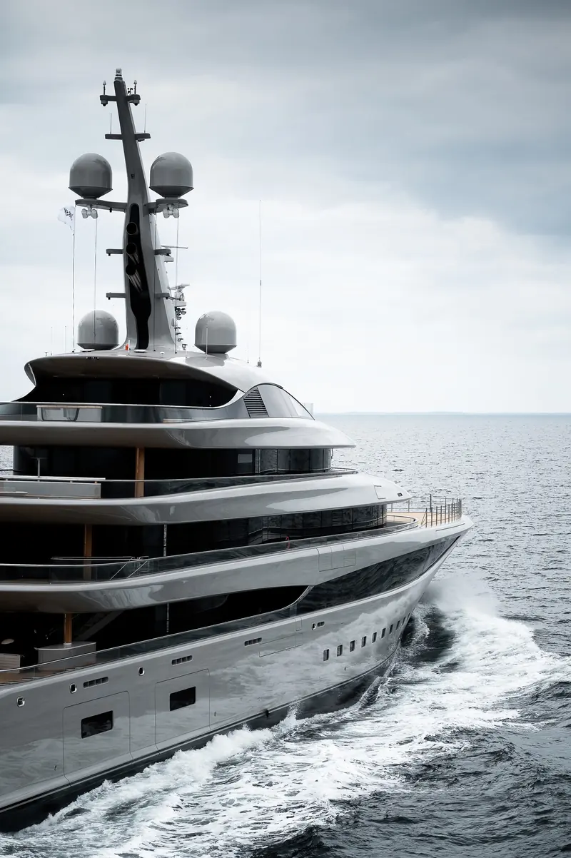 Bow-on, Nixie's mast cluster and forward deck rail are framed by the wake thrown either side of the hull.