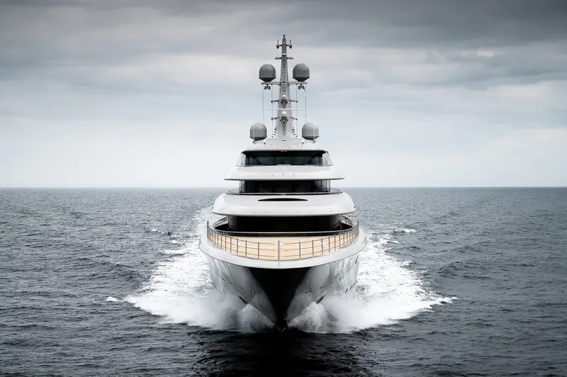 A lower three-quarter view from the beam shows the tiered deck lines and dark glazing that run the length of the superstructure.