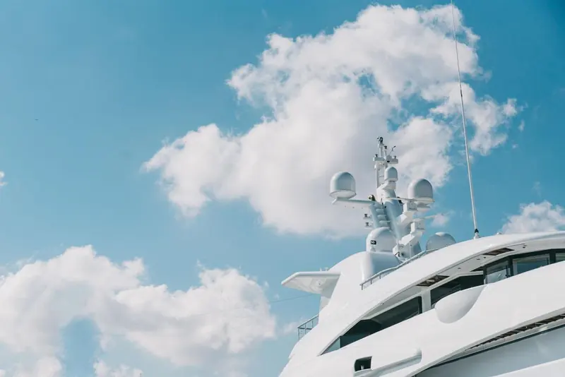 A yacht's mast and radar arch stand against the sky at MB92 Barcelona, the kind of large refit project the yard's berths for vessels up to 220 metres are built around.