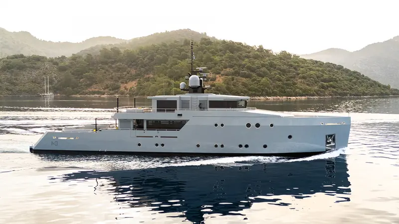 Underway off Turkey's Gulf of Gokova at low light. The epoxy-and-wood hull and raised pilothouse are Tansu's own design, built to Riza Tansu's lines rather than a naval architect brought in from outside.
