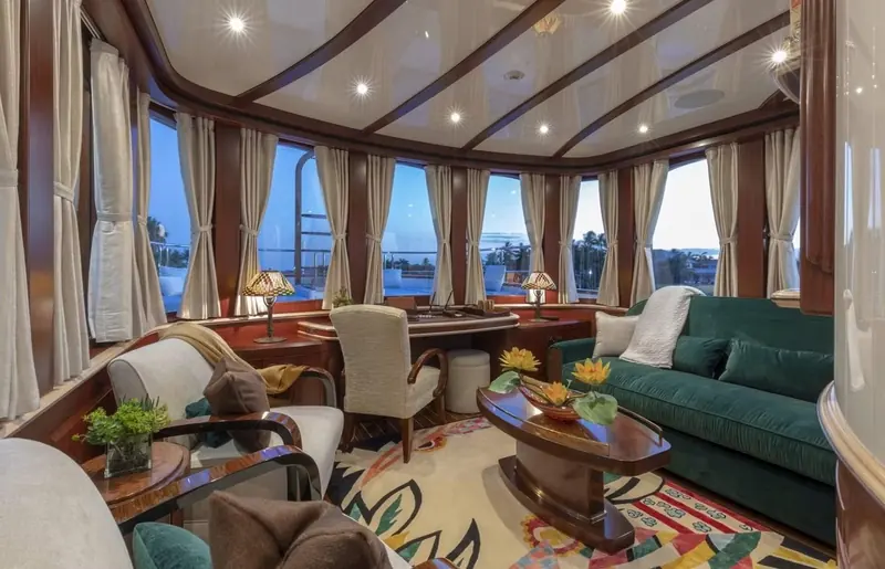The main saloon's raised wall panels and warm palette are part of Ken Freivokh's interior, styled to evoke the golden age of motor yachting rather than a contemporary all-white saloon.