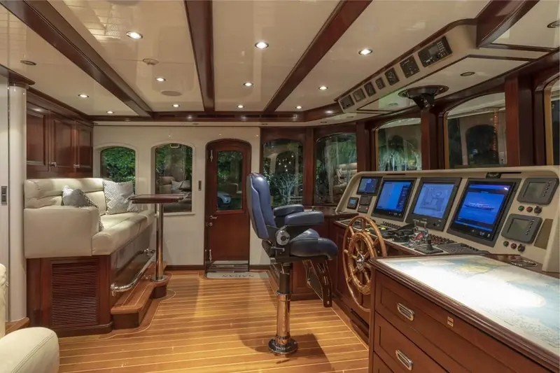 The wheelhouse keeps its analogue-style dials and wood joinery alongside modern navigation displays, twin Caterpillar engines running below.