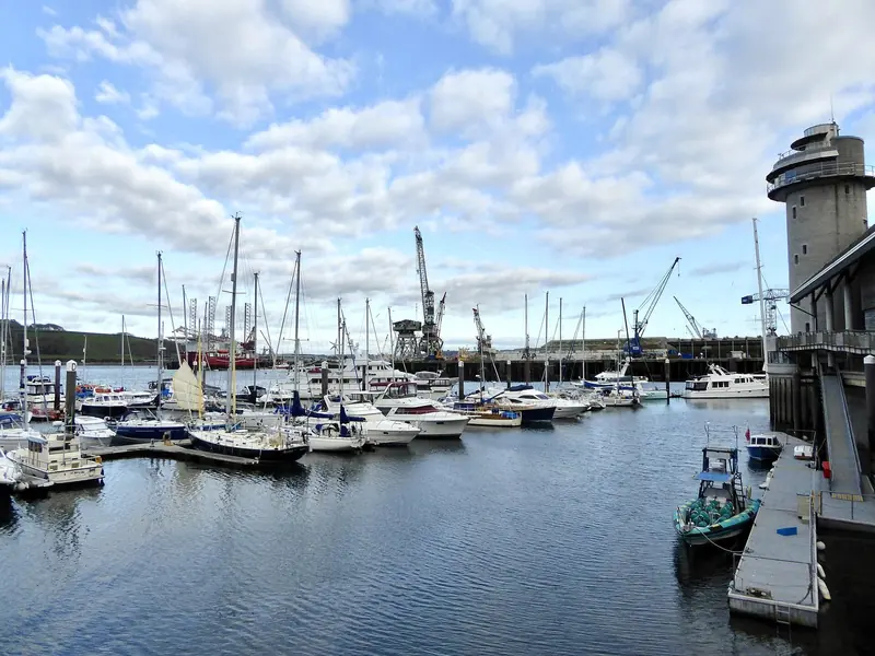 The inner harbour under the National Maritime Museum tower, with the commercial dock cranes working just beyond. Falmouth is a deep natural harbour at the western end of the Channel, which is what makes it reachable but also a long way from the Mediterranean.