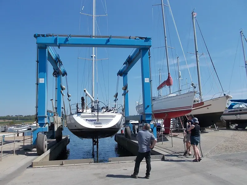 A travel lift takes the weight off the hull for the out-of-water inspection - the phase every standard scope calls the condition survey. Pepper comes ashore at Island Harbour marina, Isle of Wight.