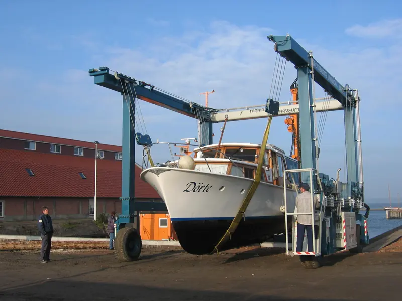 Out of the water is the only place a surveyor can check for blistering, prior repairs and corrosion below the waterline. A Marine Travelift brings a motor cruiser ashore near Lingen, Germany.