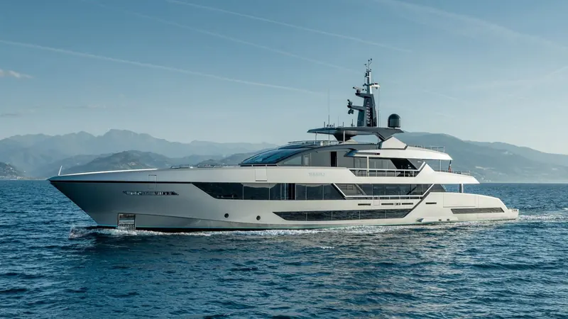 A second running shot of Sairu, name visible on the hull, against the Mediterranean coastline she was built to cruise.
