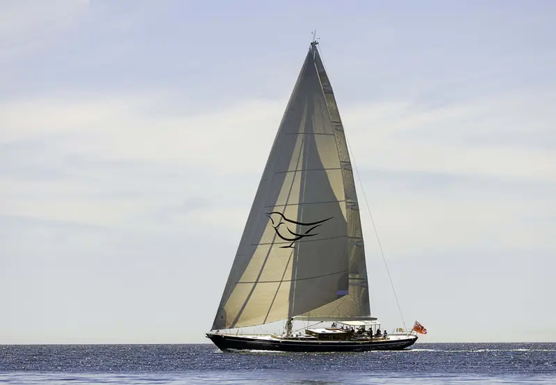 A distant broadside view under full sail, showing the low, classic-cutter sheer line drawn by Langan Design Partners.
