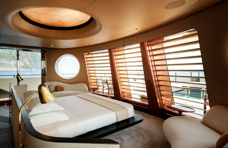 The owner's cabin has a lit oval ceiling panel, timber louvres across the curved glazing and a round window.
