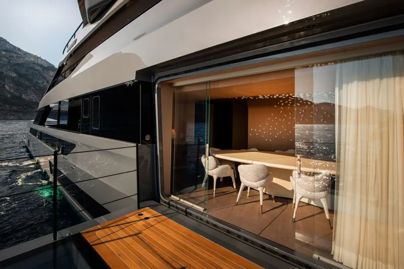 The dining room seen from the fold-down starboard balcony, with the glazing slid open towards the water.