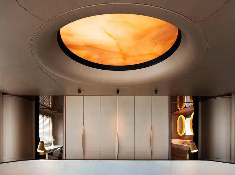 Another view of the owner's suite, with a glowing ceiling panel and softly curved wardrobe doors.