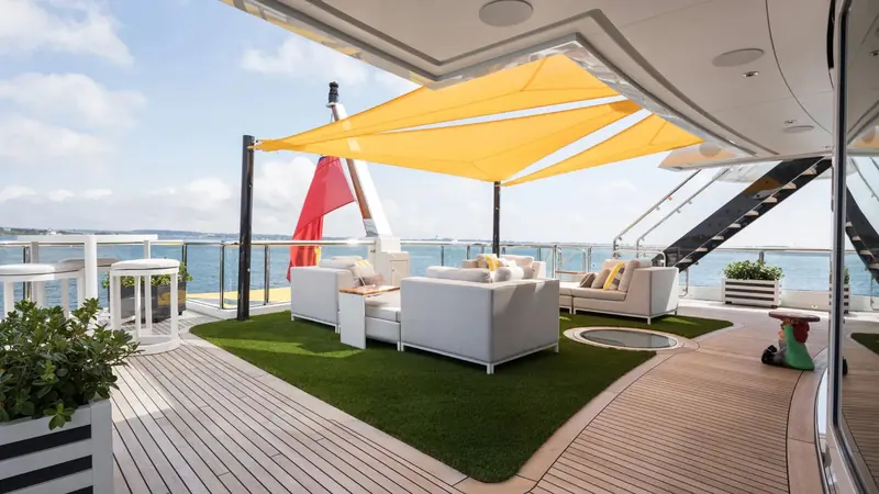 The owner's deck aft, with astroturf, director's chairs and a house flag - the casual, no-formal-dining brief H2 Yacht Design built the whole interior around.