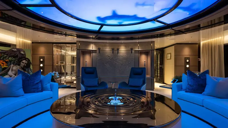 The main saloon, its blue-lit ceiling graphic and William Steiger collage artwork carrying the Jules Verne theme through the boat.