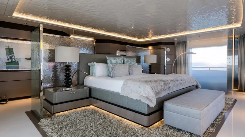 The owner's cabin, hammered-metal panelling and a ship's-cabin porthole motif standing in for the formal joinery a yacht this size usually carries.