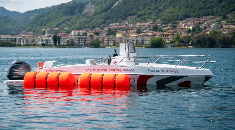 A second demonstration boat, on an Italian lake, carries the same red airbags and the company's own tagline painted on the hull.