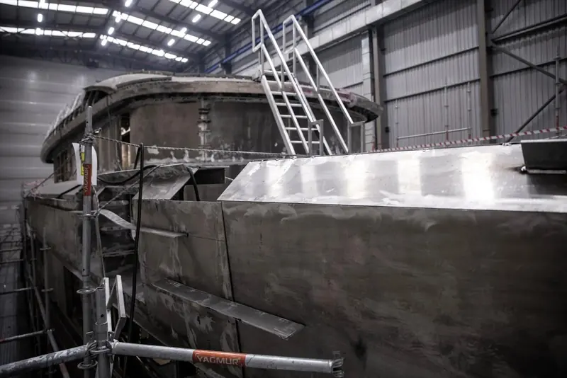 The hull takes shape on its cradle, plate seams still raw ahead of fairing - the flagship is built in steel, not the aluminium of Sirena's smaller line.