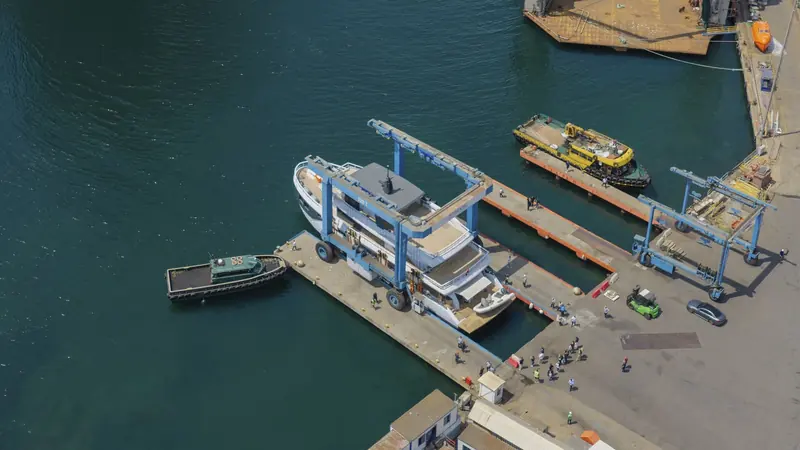 Seen from above, Lointaine sits alongside the quay with a tug standing by - the aerial view Boat International's own launch coverage used to show the full basin.