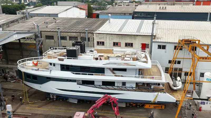 Days from launch, crates of outfitting equipment still sit on the sundeck and a tender waits on its chocks aft - the ordinary, unglamorous state most launch photography skips past.